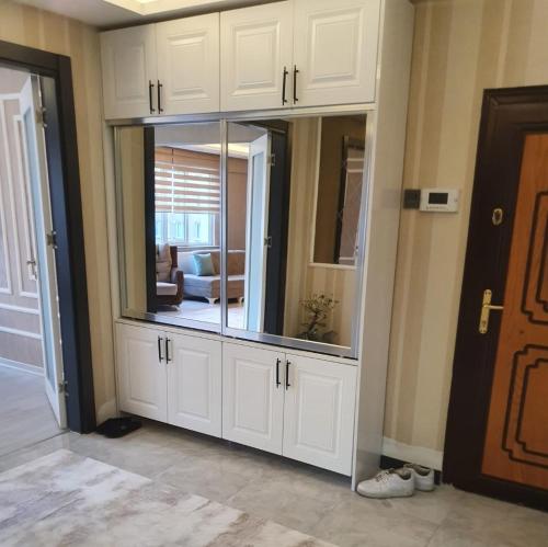 a large white cabinet with a large mirror in a room at Mükemmel Konum'da Lüx Dairede Konaklama in Sivas