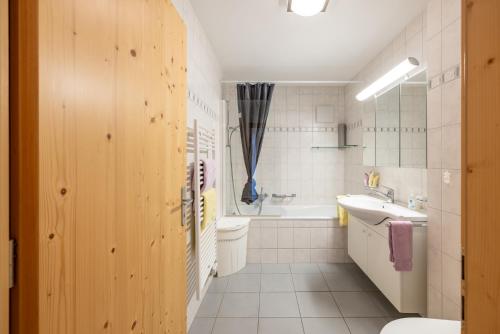 a bathroom with a sink and a toilet and a tub at Trü-Sura Nr. 7 in Scuol