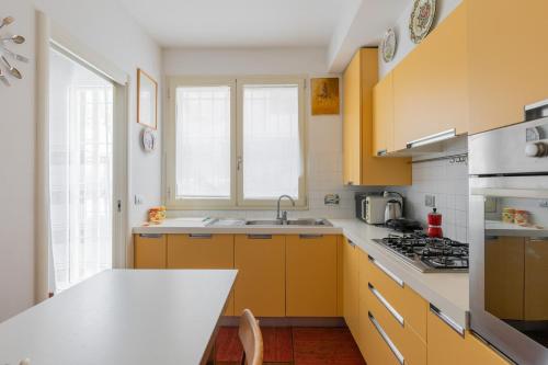 cocina con armarios amarillos y encimera blanca en Zola Predosa Apartment by Wonderful Italy, en Zola Predosa