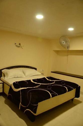 Un dormitorio con una cama con una manta blanca y negra. en Hotel Bindra Paradise 800 Meter From Golden Temple, en Amritsar