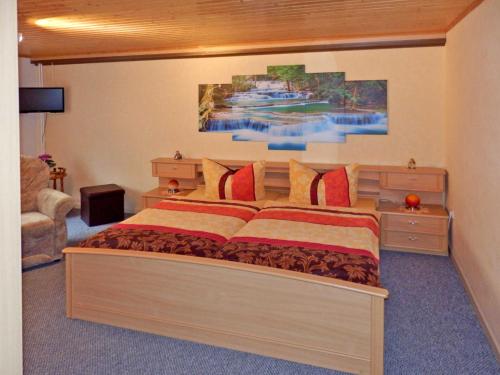 ein Schlafzimmer mit einem großen Bett und einem Gemälde an der Wand in der Unterkunft Ferienwohnung unweit der Müritz in Gotthun