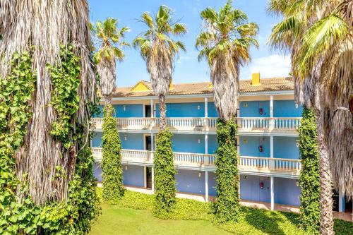 una vista exterior de un hotel con palmeras en Vibra Blanc Palace Aparthotel, en Sa Caleta