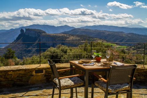 a table and chairs with a view of the mountains at Santa Llúcia Rupit in Rupit