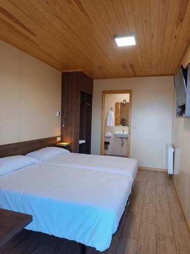 a bedroom with a large white bed and a bathroom at Motel 112 in Algora