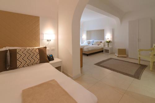a bedroom with a bed and a living room at Hotel Moresco in Santa Teresa Gallura