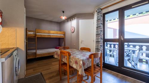 a room with a table and a bunk bed at Grande Neige 23 - Appt pied des pistes 4 pers in Morillon