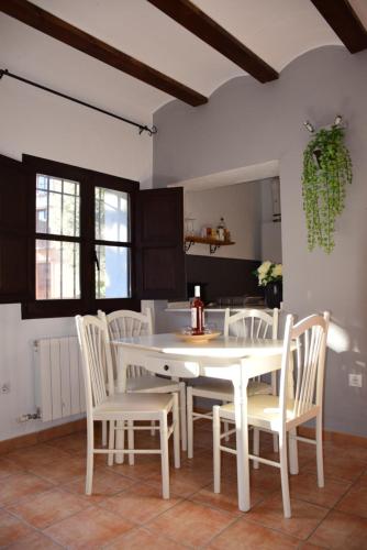 a kitchen with a white table and white chairs at Oasis rural in Los Pastores