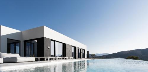 a villa with a swimming pool with mountains in the background at KATHOS RESIDENCE in Kavoúsion