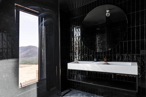 a black bathroom with a white sink and a mirror at KATHOS RESIDENCE in Kavoúsion
