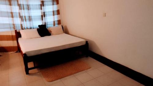 a small bed in a corner of a room at Vera comfort in Mombasa
