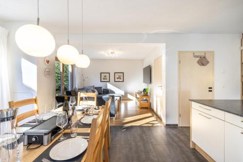 a kitchen and dining room with a dining table and a living room at Pütvia 245F in Scuol