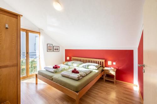 a bedroom with a large bed with a red wall at Pütvia 245F in Scuol