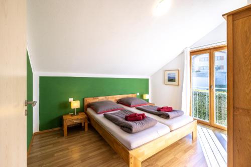 two beds in a room with a green wall at Pütvia 245F in Scuol