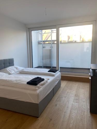 um quarto com uma cama grande e uma janela grande em Home Sweet Home Vienna - Penthouse em Viena