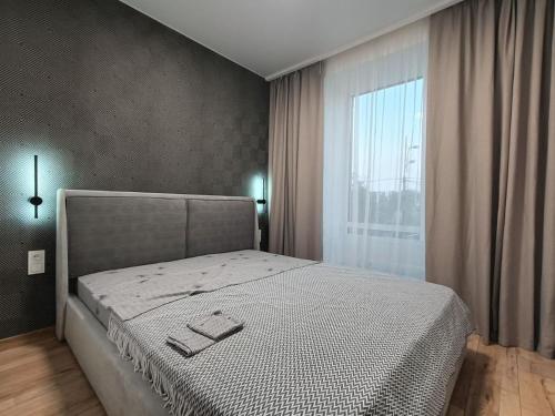 ein Schlafzimmer mit einem Bett und einem großen Fenster in der Unterkunft ЖК Аржанова (Arjanova) in Dnipro