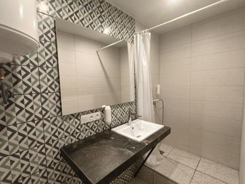 ein Badezimmer mit Waschbecken und Spiegel in der Unterkunft ЖК Аржанова (Arjanova) in Dnipro