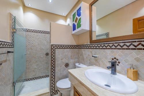 a bathroom with a sink and a shower and a toilet at L'Atlas - Appartement Authentique à Gueliz in Marrakesh