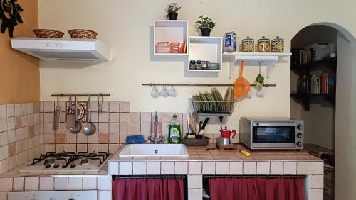 a kitchen with a counter with a sink and a microwave at Casa con Giardino in Milazzo