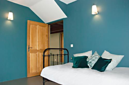 Habitación azul con cama con almohadas verdes y blancas en Chartreuse de Mougeres - Pézenas, en Caux