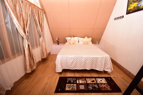 1 dormitorio pequeño con 1 cama con colcha blanca en SYLWAN-O SUNRISE HOMESTAY, 