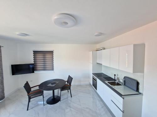- une cuisine avec une table et des chaises dans la chambre dans l'établissement Apartments Filipo, à Trogir