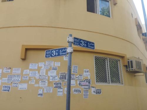a street sign with signs on it next to a building at Sphinx Hostel in Dubai