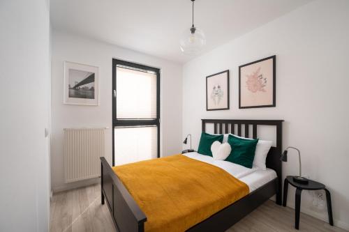 sypialnia z łóżkiem z zielonymi i białymi poduszkami w obiekcie Royal Wilanów Comfort Apartment w Warszawie
