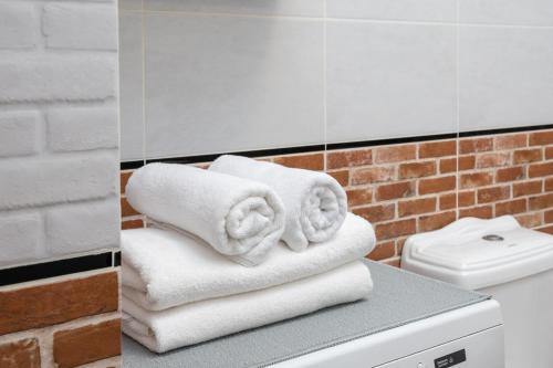 a pile of towels sitting on top of a toilet at Royal Wilanów Comfort Apartment in Warsaw