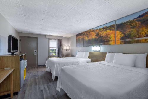 a hotel room with two beds and a flat screen tv at Days Inn by Wyndham Lincolnton in Lincolnton