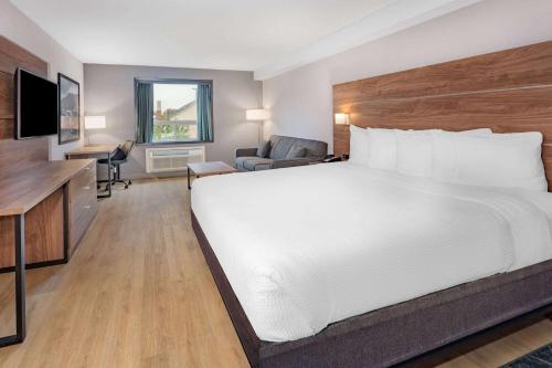a hotel room with a large bed and a television at Super 8 by Wyndham Cornwall ON in Cornwall