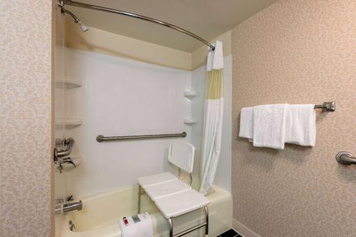 a bathroom with a tub and a toilet and towels at Howard Johnson by Wyndham Salem Hotel & Conference Center in Salem