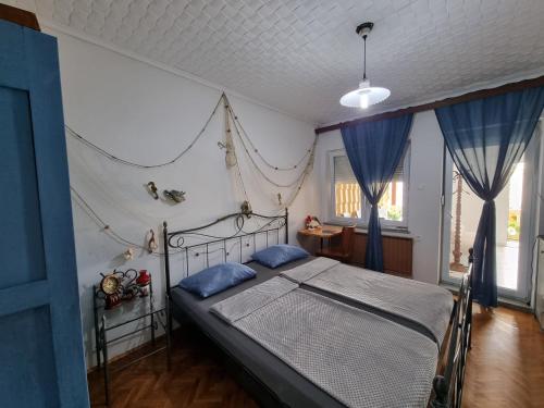 1 dormitorio con 1 cama con cortinas azules en Vila Antik, en Ilirska Bistrica