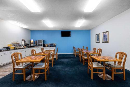 a dining room with wooden tables and chairs at Days Inn by Wyndham Roswell in Roswell