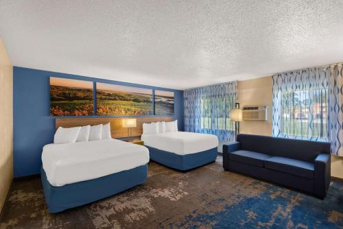 ニュートンにあるDays Inn by Wyndham Newtonのベッド2台とソファが備わるホテルルームです。