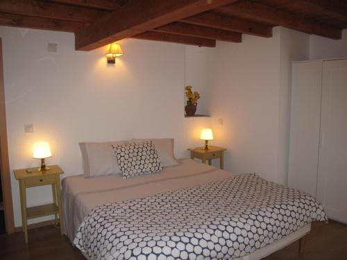 a bedroom with a bed with two lamps on two tables at Casa do Castelo - Coroa in Castelo de Vide