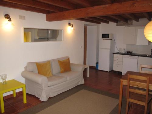 a living room with a couch and a kitchen at Casa do Castelo - Coroa in Castelo de Vide