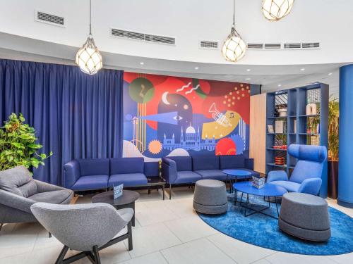 a waiting room with blue couches and a mural at Ibis Budapest Centrum in Budapest