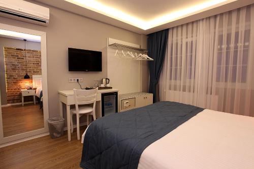 a bedroom with a bed and a desk and a television at Taksim Santa Lucia Hotel in Istanbul