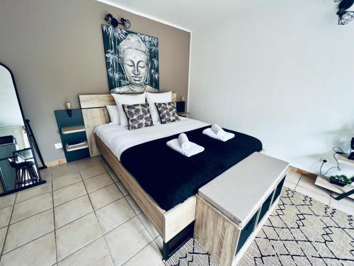 a bedroom with a bed with a statue of a head at "Le studio Bouddha" Studio avec terrasse, centre ville, proche gare, by PRIMO C0NCIERGERIE in Nevers