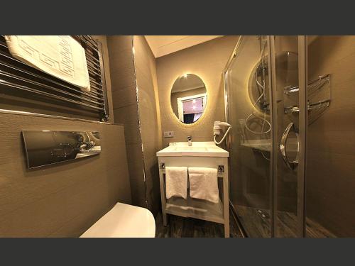 a bathroom with a toilet and a sink and a mirror at Taksim Santa Lucia Hotel in Istanbul