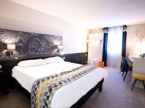 - une chambre avec un lit et un mur orné de dessins dans l'établissement Ibis Styles Cognac, à Châteaubernard