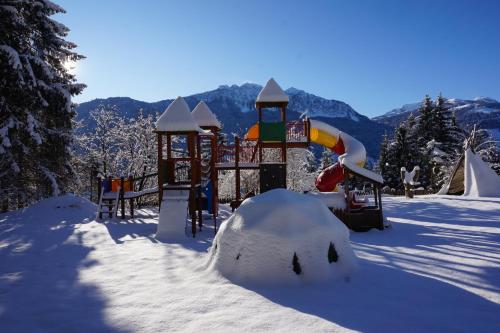 a playground covered in snow with a snow igloo at nawu apartments & Restaurant in Hermagor