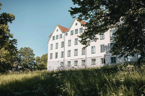 un grande edificio bianco in mezzo a un campo di Best Western Solhem Hotel a Visby