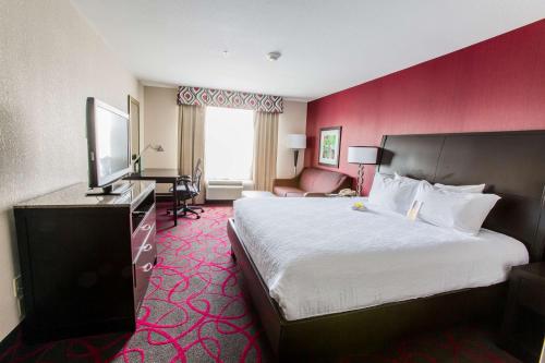 a hotel room with a large bed and a television at Hilton Garden Inn Columbus/Dublin in Dublin