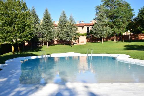 a swimming pool in a yard with trees and a building at Oasis rural in Los Pastores