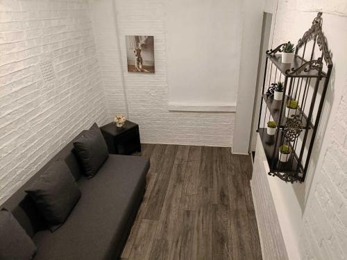 a living room with a couch and a white wall at Comfortable Budget Two Bedroom Apartment In City Centre - Kings Cross - Euston Station - 6 People in London