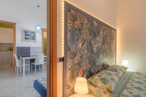 Un dormitorio con un tapiz en la pared junto a una cama. en Cascina di Barone - Vista mare, en Noto