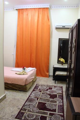 a bedroom with an orange curtain and a bed with a rug at City View Museum Hotel in Cairo