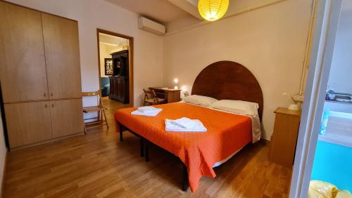 ein Schlafzimmer mit einem Bett mit einer orangefarbenen Decke in der Unterkunft Giulio in Santo Spirito in Florenz