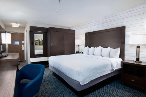 una habitación de hotel con una cama grande y una silla azul en Hampton Inn Durango, en Durango
